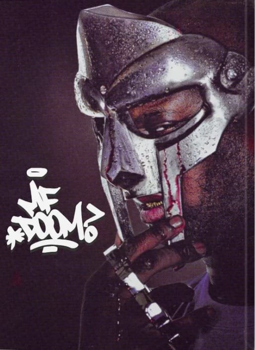 Närbild på en MF DOOM poster med den klassiska metallmasken och hans tag.