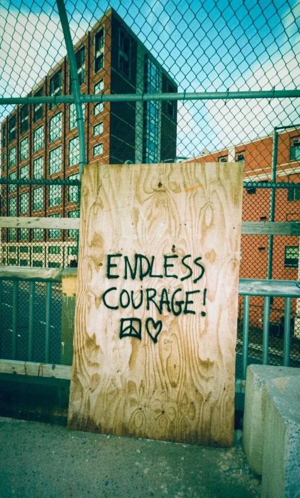 En träskiva med texten ”ENDLESS COURAGE!” i graffiti, fotograferad av Remedeeh inför hennes nya utmaning som Resident Advisor.