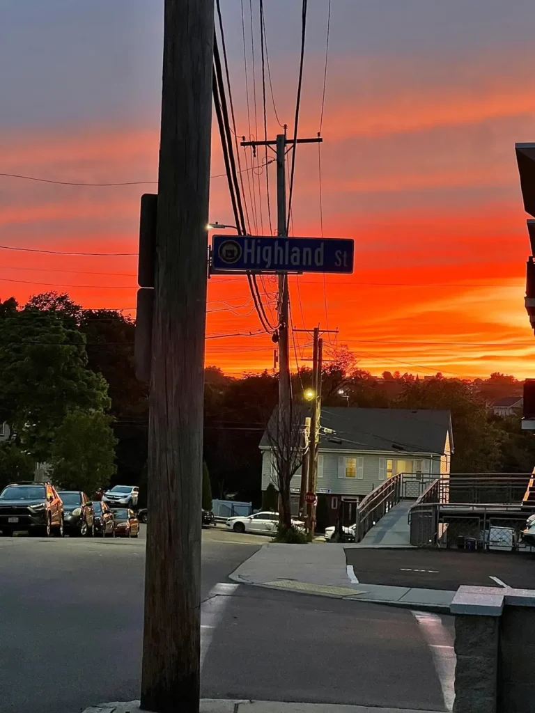 En färgstark solnedgång över Highland Street i Roxbury, Boston, som illustrerar Remedeehs sökande efter sitt syfte och jobb i USA.