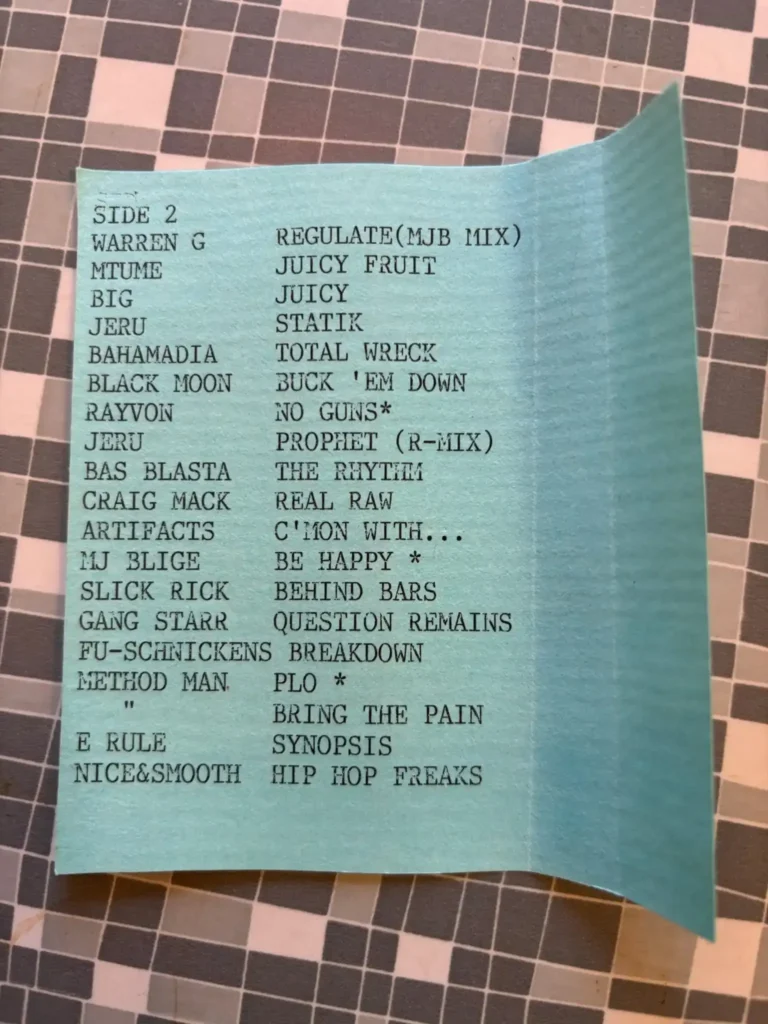 Handskriven tracklist på ett ljusblått papper för DJ Will Rock Mixtape Nr 1 Sida 2 (Sida B). Listan inkluderar artister som Warren G, Notorious BIG, Jeru, Gang Starr och Method Man från 1994.