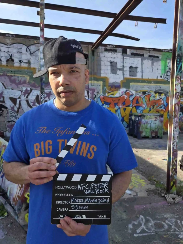Ramo från AFC i blå Big Twins T-shirt håller i filmklappran för Världen är för liten