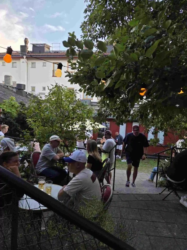 Gäster minglar och sitter vid caféborden på Årstabos innergård.