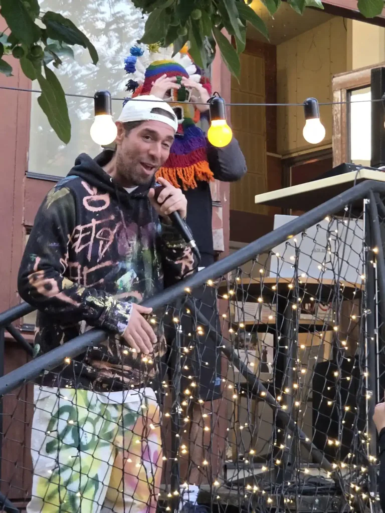 Gonza rappar direkt mot kameran med mikrofon på Årstabos utomhusscen.
