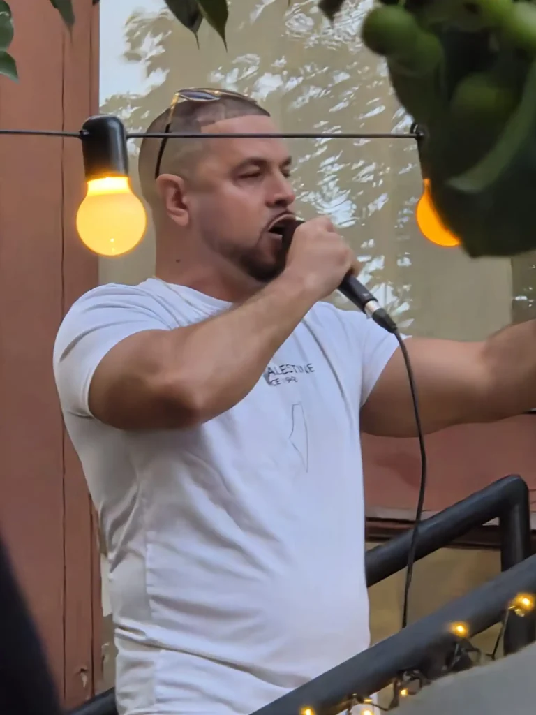 Hoosam rappar i mikrofonen under sin liveakt på Årstabos utomhusscen.