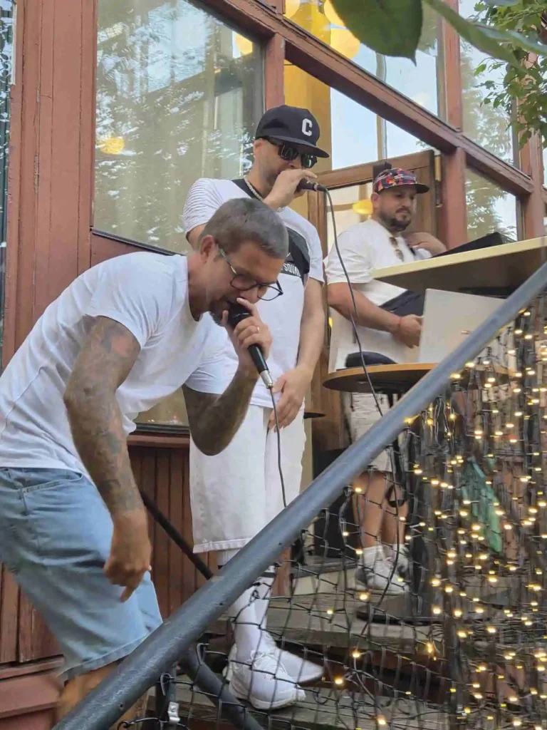 Närbild på rappare i Low Key Dwellas framför mikrofonen under konserten.