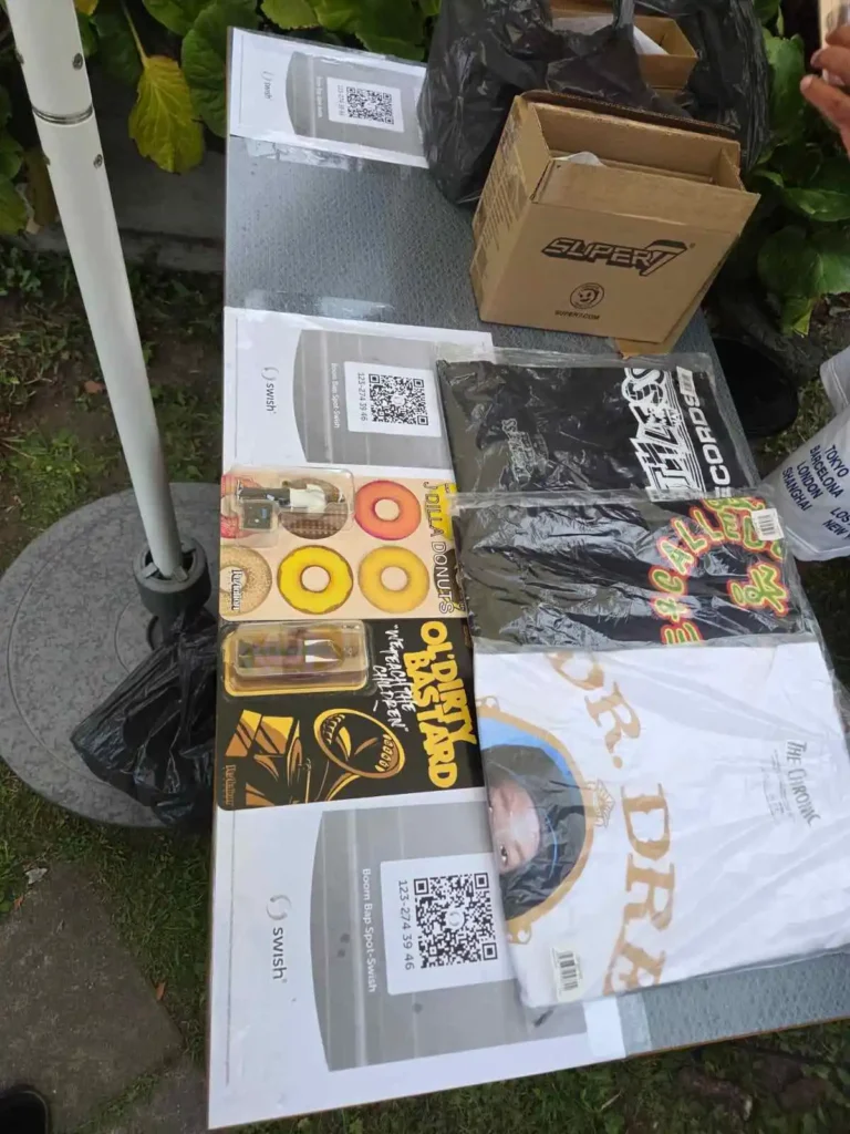 Pop-up merchbord med samlarobjekt, t-shirts och Swish-skyltar på Årstabo.