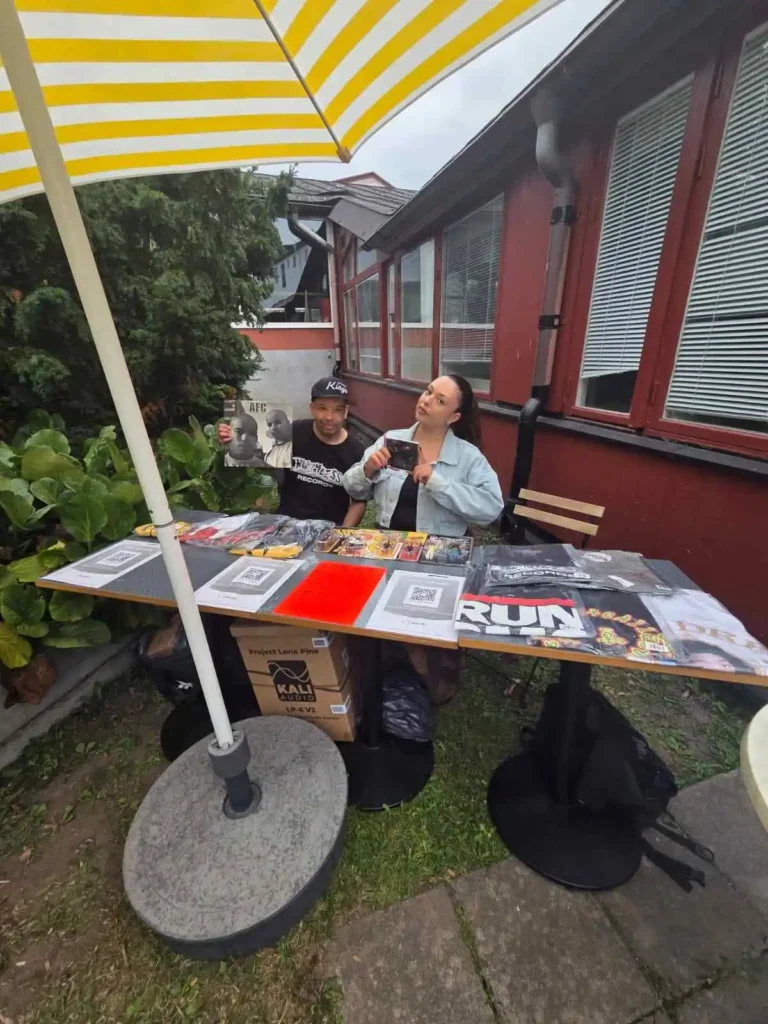 Ramo från AFC och Amira vid Boom Bap Spots merchbord utomhus.