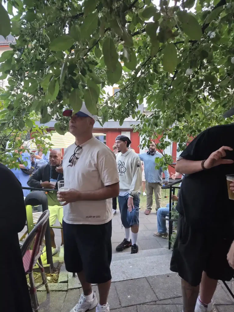 Besökare och hiphopentusiaster minglar under träden på Årstabo