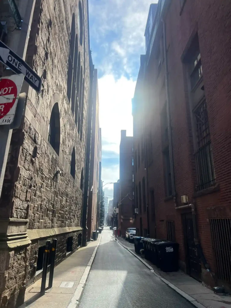R2 26-8 En smal tegelgränd med brandstegar i downtown Boston en solig dag