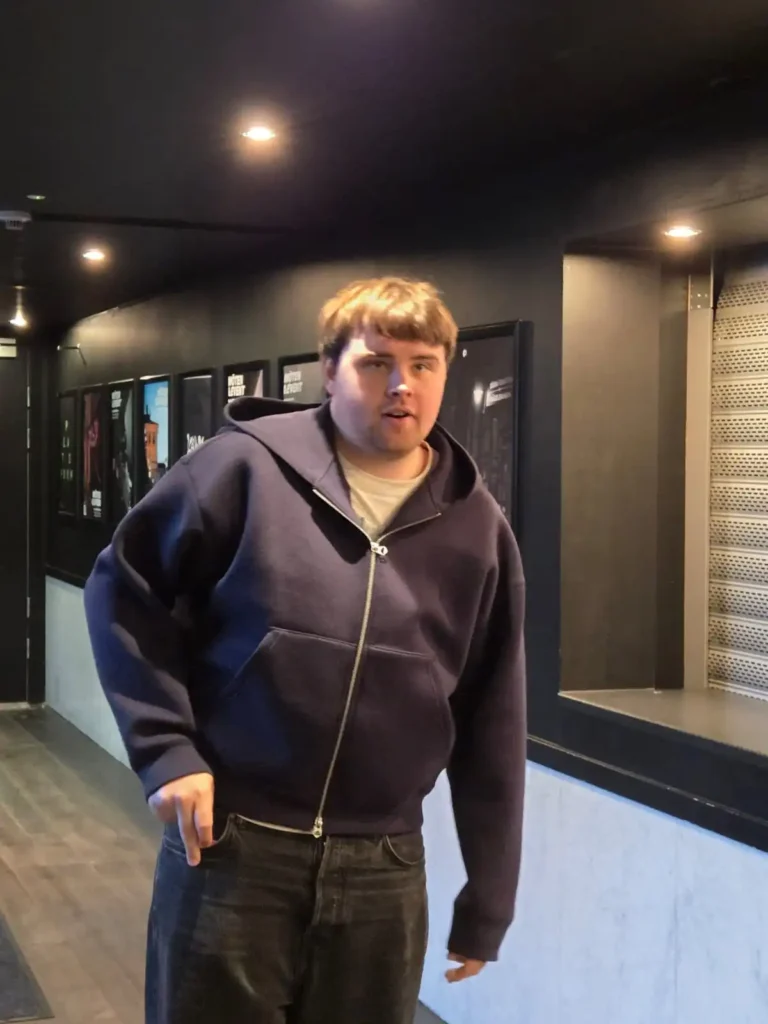 Hiphop-artisten Eah Jé i blå huva och svarta jeans på väg ut backstage